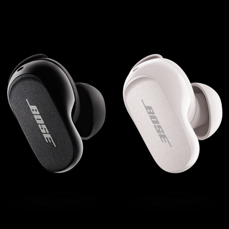 Bose QuietComfort Earbuds II shown in two colours, triple black and soapstone, each with its stability band and the Bose wordmark